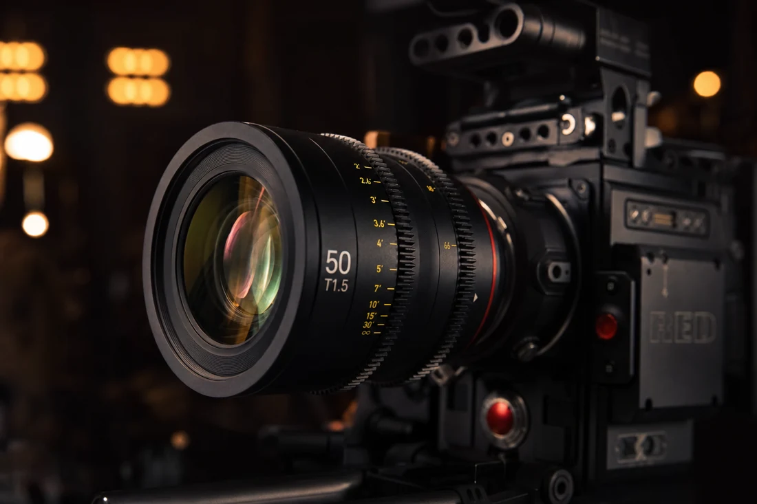 Cámara de cine con lente y luces cálidas de fondo